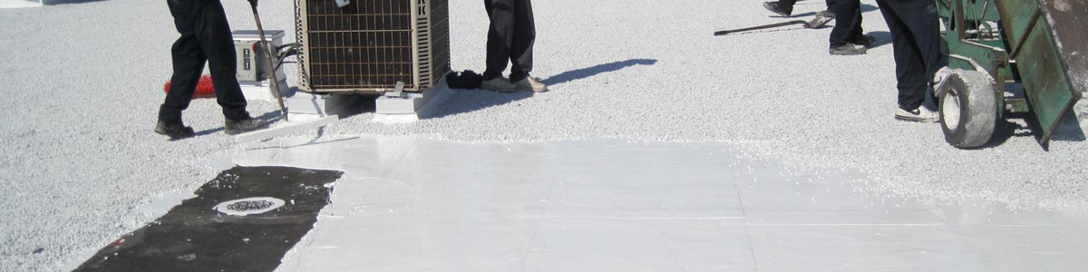 Les travailleurs appliquent un adhésif blanc autour d'une unité de climatisation sur un toit commercial.